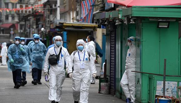 Trabajadores de la salud caminan por una calle mientras las autoridades continúan realizando pruebas en el área de Jordan en Hong Kong. (Foto: Peter PARKS / AFP)