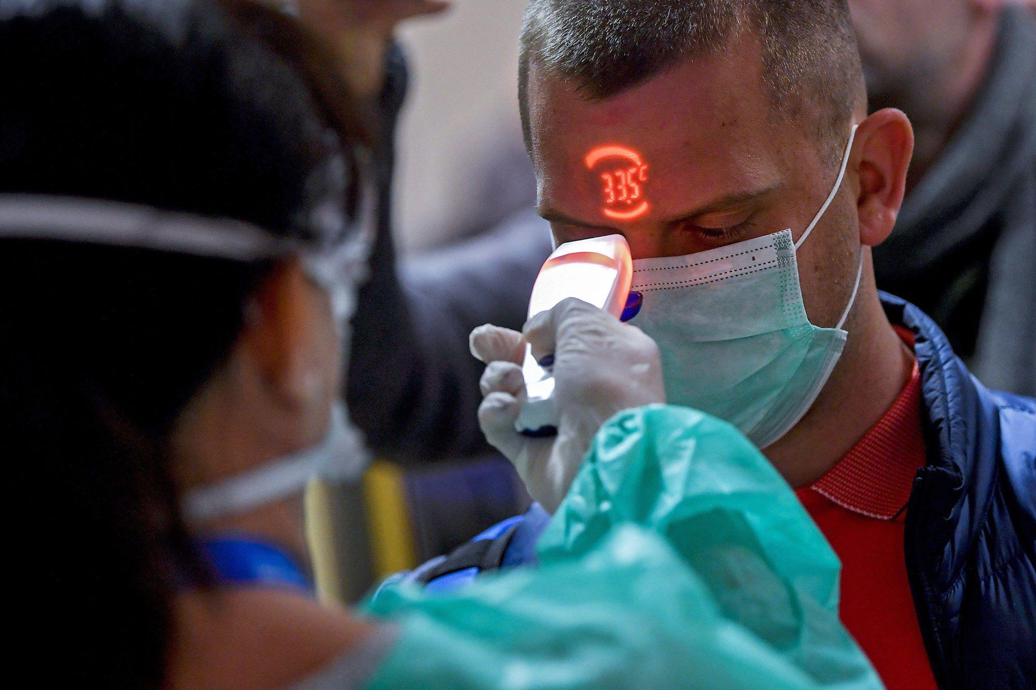 La OMS publicó un documento con recomendaciones para todos los países. La toma de temperatura es lo primordial en la detección de casos de coronavirus. En la foto, un pasajero es examinado en un aeropuerto de Hungría. Foto: EFE
