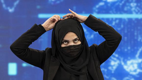 Una presentadora de TOLOnews, Thamina Usmani, se cubre el rostro durante una transmisión en vivo en la estación de televisión Tolo en Kabul el 22 de mayo de 2022. (Foto de Wakil KOHSAR / AFP)