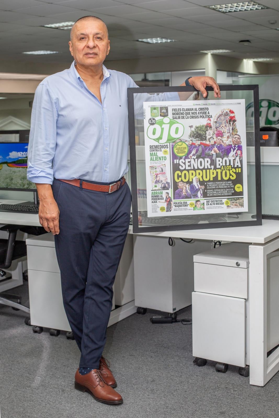 Director Carlos Espinoza Olcay posando con una de las portadas de diario OJO.