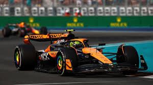 Lando Norris va delante de Max Verstappen hacia la meta.