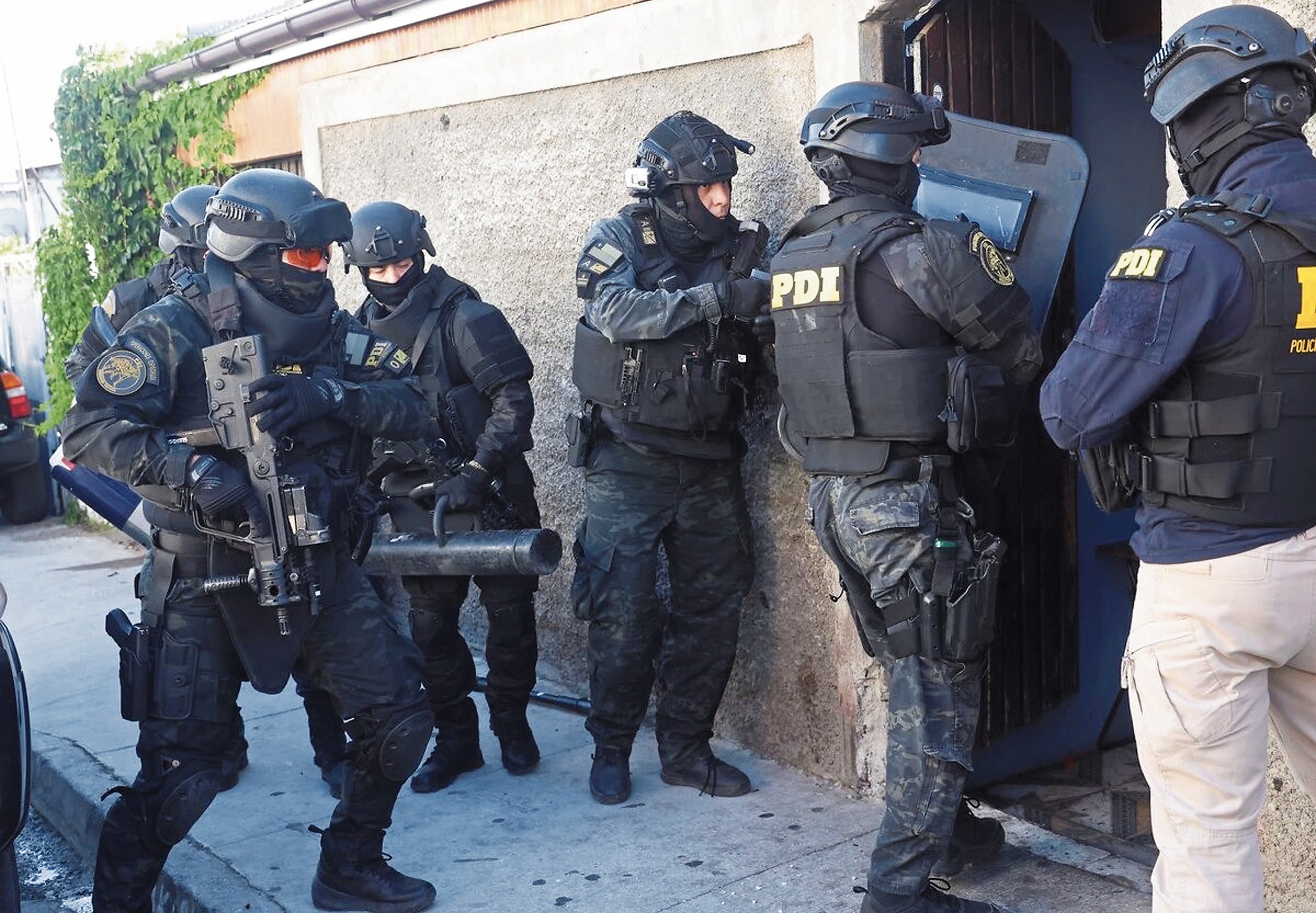 Los policías chilenos ingresan para realizar una de las capturas, en Santiago de Chile.