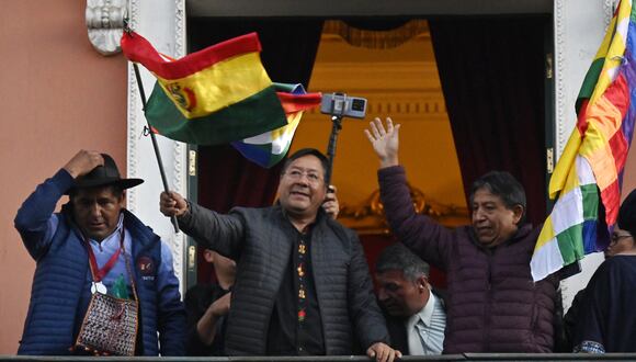 El presidente Luis Arce ondea una bandera de Bolivia en el balcón del Palacio de Gobierno en La Paz el 26 de junio de 2024, tras un intento de golpe de Estado. (Foto de AIZAR RALDES / AFP).