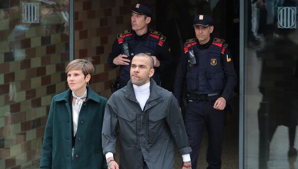 Convicted rapist and former Brazil international football player Dani Alves (R) leaves on provisional release, flanked by his lawyers Ines Guardiola, at Brians 2 prison in Barcelona on March 25, 2024. Convicted rapist and former Brazil international Dani Alves left a jail in Barcelona on March 25, 2024 after posting the one-million-euro bail set by a Barcelona court to ensure his release pending appeal. Ex-Brazil star has been sentenced to 4.5 years in jail for rape on February 22, 2024. (Photo by LLUIS GENE / AFP)