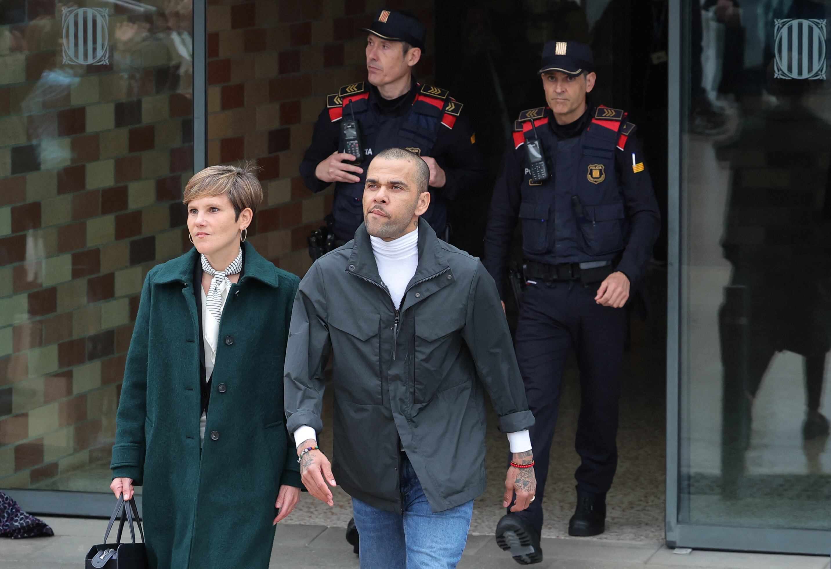 Convicted rapist and former Brazil international football player Dani Alves (R) leaves on provisional release, flanked by his lawyers Ines Guardiola, at Brians 2 prison in Barcelona on March 25, 2024. Convicted rapist and former Brazil international Dani Alves left a jail in Barcelona on March 25, 2024 after posting the one-million-euro bail set by a Barcelona court to ensure his release pending appeal. Ex-Brazil star has been sentenced to 4.5 years in jail for rape on February 22, 2024. (Photo by LLUIS GENE / AFP)