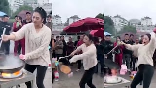 Mujer cocina fideos en un enorme wok mientras baila Gangnam Style de PSY