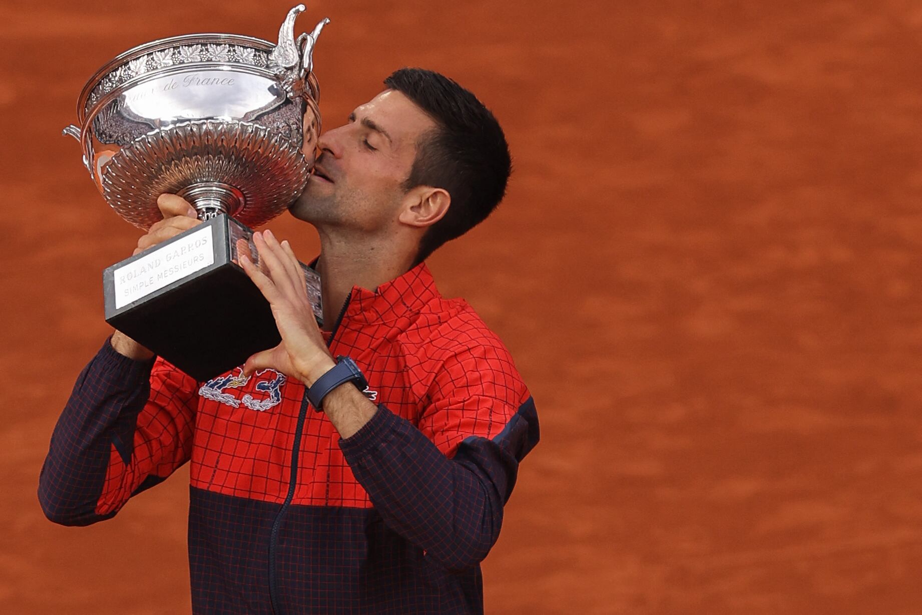 Serbia's Novak Djokovic kisses the trophy as he celebrates his victory over Norway's Casper Ruud during their men's singles final match on day fifteen of the Roland-Garros Open tennis tournament at the Court Philippe-Chatrier in Paris on June 11, 2023. (Photo by Thomas SAMSON / AFP)