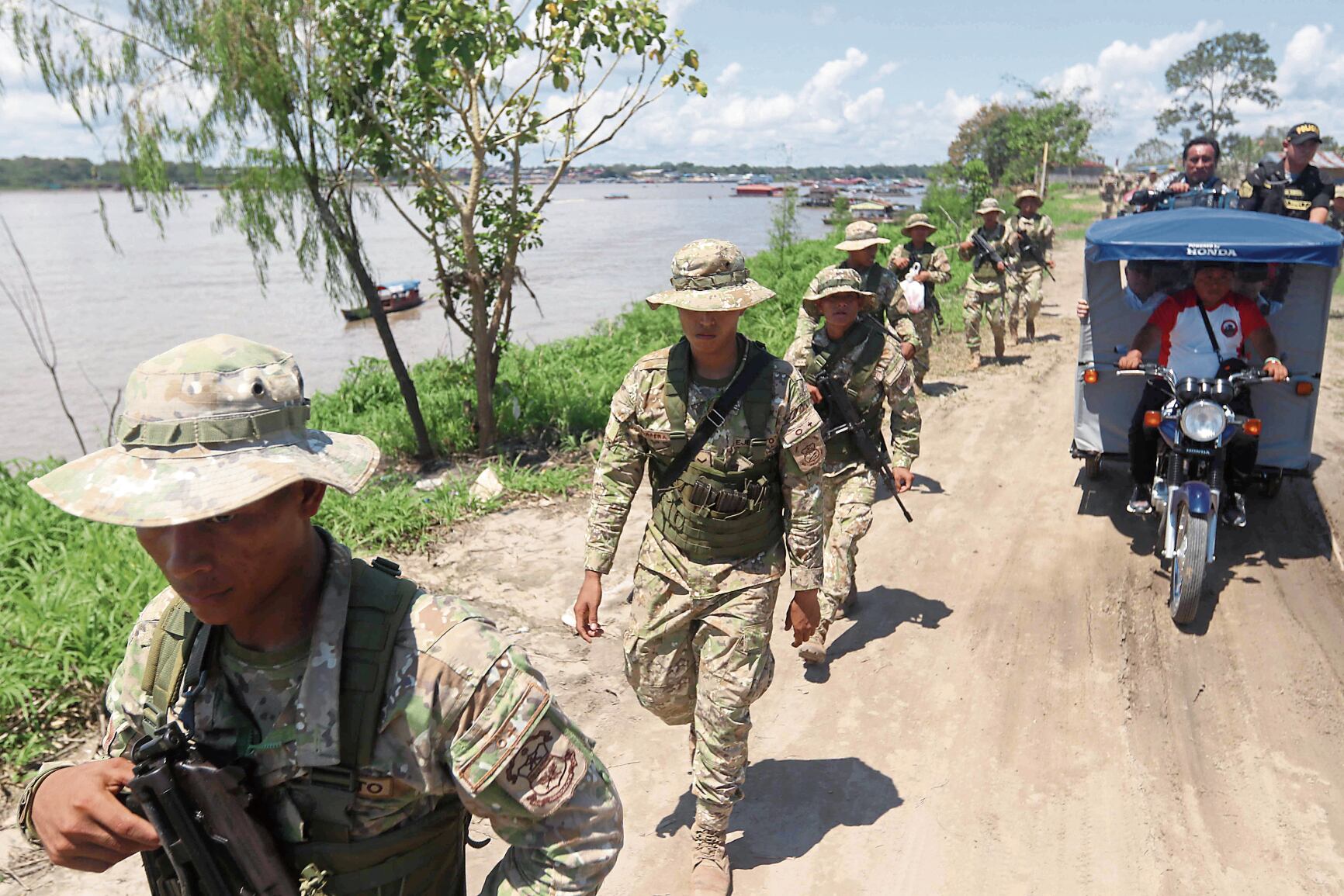 Integrantes de una patrulla militar recorren un camino este miércoles, en la población de Santa Rosa, una isla en medio del río Amazonas bajo soberanía peruana, situada frente a la ciudad colombiana de Leticia, en la triple frontera amazónica con Brasil. EFE/ Stringer