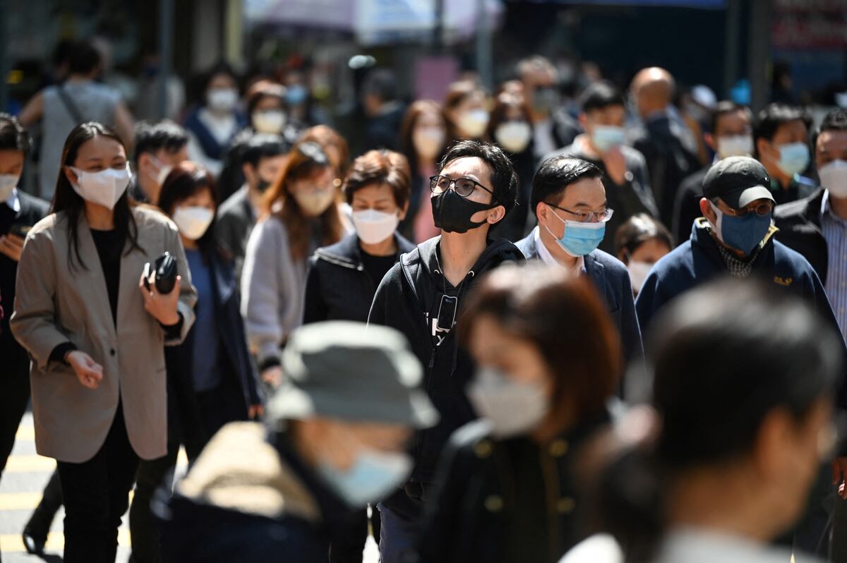 La gente usa máscaras en una calle de Hong Kong el 27 de febrero de 2023 cuando los expertos en salud en el territorio respaldaron la extensión de su mandato de máscara hasta el 8 de marzo, dejando a Hong Kong como uno de los únicos lugares del mundo con tales reglas. (Foto de Peter PARQUES / AFP)