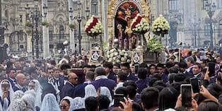 Jóvenes cargan el anda del Señor de los Milagros por la Plaza de Armas de Lima.