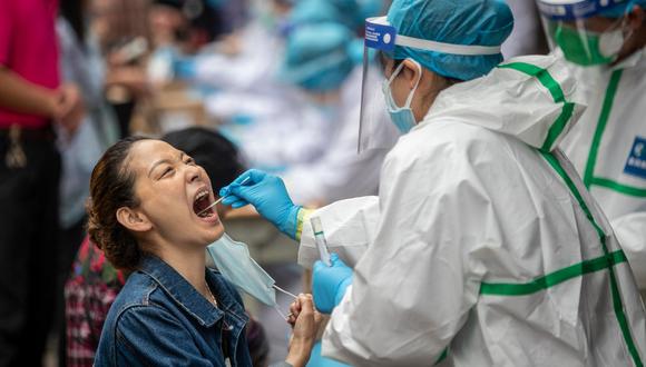 A medical worker takes a swab sample from a resident to be tested for the COVID-19 coronavirus, in a street in Wuhan in China's central Hubei province on May 15, 2020. - Authorities in the pandemic ground zero of Wuhan have ordered mass COVID-19 testing for all 11 million residents after a new cluster of cases emerged over the weekend. (Photo by STR / AFP) / China OUT