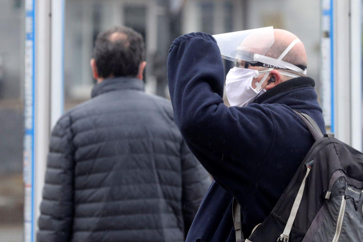 Un hombre con una protección de fabricación casera espera el autobús en las inmediaciones de Atocha este lunes, primera jornada para muchos ciudadanos que regresan a sus trabajos tras el fin de la restricción a las actividades económicas no esenciales, en la que se activará el dispositivo organizado por el Ministerio del Interior para reforzar los controles al transporte público y repartir mascarillas. (Foto: EFE/ JuanJo Martín)