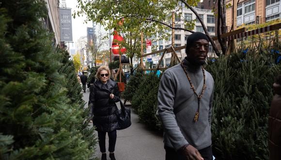 La gente pasa frente al mercado de árboles de Navidad en Nueva York el 2 de diciembre de 2021. (Foto de Yuki IWAMURA / AFP)